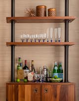 Custom walnut bar cabinet with grass cloth wallcovering.