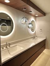 Primary bathroom with 9ft. custom cabinetry vanity, lighted mirrors, and "Galactic" pendants. We removed a sink in a closet in order to make this bathroom larger and more fitting for a primary bathroom. 