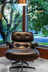 The Eames chair sits perfectly in the corner windows, which have new wood paneling. 
