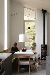 Dining Room, Chair, Bench, Two-Sided Fireplace, Pendant Lighting, Table, Wood Burning Fireplace, and Concrete Floor  Photo 14 of 42 in Atelier C by Nicholas Francoeur