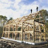 Exterior, Gable RoofLine, and House Building Type Fearless Amish timber framers inspecting their work.  Photo 5 of 13 in House in the Woods by Dustin Ehrlich