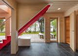 The staircase is painted Red by Benjamin Moore, which serves as a jolt of energy against the tones and textures of natural wood.&nbsp;