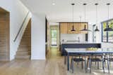 Kitchen, Pendant Lighting, and Light Hardwood Floor "The minimalist nature of the interior draws focus to the natural beauty surrounding the home.”  Photo 12 of 17 in The Best Scandinavian-Inspired Paint Colors for Your Home, According to Experts