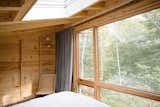 In the sleeping loft, floor-to-ceiling windows offer an immersive nature view. An above-bed skylight encourages stargazing in the evenings. &nbsp;