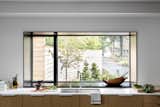 An attractive gravel driveway and contemporary landscaping is viewable from the expansive kitchen window, originally the eight foot wide carriage house garage door. Now the wall is two feet deep, allowing for plants and decor to sit happily on the sill.