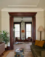 Dark wood details, cream walls and a neutral palette makes for a relaxed parlor space. All of the furnishings are intended to be hard-wearing and comfortable.