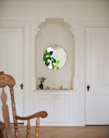 The clients opted to preserve an original sink in the primary bedroom. “Because they were open to it, we kept it there–it’s cute and quirky,” says Jacoby. The wood floor extends into the bath.