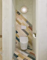 Marble Clé tile, installed diagonally, creates a striking backdrop in the primary bathroom. The Alien Orb surface mount light is from In Common With.