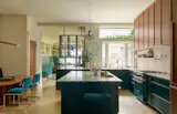 A bold BlueStar range set the palette for the kitchen, which is steeped in rich color. Walnut cabinetry and warm-toned furnishings add an inviting, lived-in feel.