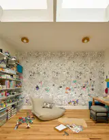 The top-floor playroom has coloring book–inspired wallpaper and open-air bookshelves.   