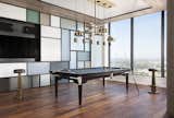 At first glance, this high-rise didn’t appear to have the space to accommodate our client's love of billiards. But we found a clever workaround, customizing a blackened mahogany billiards table that easily converts into a dining table, paired with Blackman Cruz stools