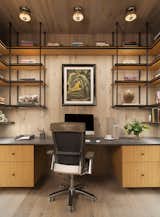 A clean elevated home office featuring custom shelving and Urban Electric light fixtures on the ceiling. 