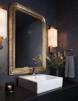 An elegant powder room with gilded antique mirror. 