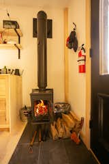 Living Room, Wood Burning Fireplace, Light Hardwood Floor, and Porcelain Tile Floor Wood stove  Photo 3 of 8 in Camp Ervay by CAMP ERVAY
