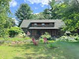 Front of 1880s cabin in summer with garden. 