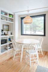 Removing some shelves and painting it white helps the coffee station feel more integrated in the space with the breakfast nook. Electricity needed to be brought to the shelving to power the appliances. A large picture window look out to the barn with new light fixture. 
