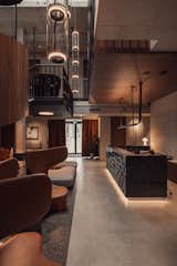 Raw architectural concrete, walnut doors without straps, leather hanging lamps above the receptions, leather curtains at the entrance.