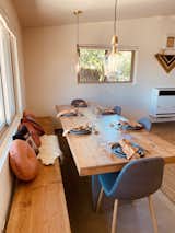 An open floor concept meets a massive reclaimed wood dining table upon entry for hosting dinner parties and Zoom calls alike