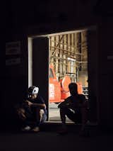 Two cyclists sit in the doorway between the Mill District Velo Club bike shop and its pop-up event space.