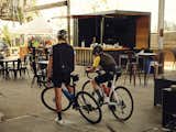 Two cyclists prepare to leave for a ride in front of the pop-up space used to host Mill District Velo Club events in Healdsburg.