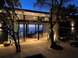 The terrace and the trees are subtly illuminated creating a cozy atmosphere at night