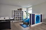 Kids Room, Light Hardwood Floor, Shelves, Playroom Room Type, Boy Gender, and Pre-Teen Age The children's play room is located adjacent to bedrooms and features a slide to save wear and tear on the stairs.  Photo 8 of 10 in Family Focused Modern by Horizon Pacific Contracting
