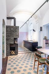 Kitchen, Metal Cabinet, Wood Cabinet, Pendant Lighting, Stone Counter, Ceramic Tile Floor, and Wall Lighting Existing floor tiles and fireplace made of color-coordinated brick  Photo 2 of 10 in Apartment in former sanatorium by studio karhard