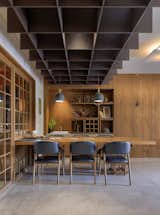 The dining area is tucked away in one corner of the central open space. The dramatic wooden ceiling with the backdrop of wooden panelling highlights this space in the entire apartment.