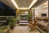 The Balcony situated at one end of the living space is made lively by plants and diffused light. The backdrop of top hung wooden windows along with niches of the study space, as well as the connection to the inside through a set of sliding doors makes this space the cosiest space in the entire apartment. 