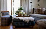 A cozy media room sits adjacent to the great room. Accent pillows and matching round ottomans by Nickey Kehoe. Vintage Hans Wegner chair and yellow gardening pots sourced at the locals' favorite shop in Cedros Design District, Solo. 
