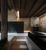 Living Room, Sofa, Floor Lighting, Wood Burning Fireplace, Concrete Floor, and Ottomans  Photo 1 of 11 in Sacré coeur, Stone House by Theo Domini