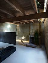 Living Room, Floor Lighting, Sofa, Ottomans, Bench, Wood Burning Fireplace, and Concrete Floor  Photo 7 of 11 in Sacré coeur, Stone House by Theo Domini