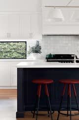 Kitchen featuring handmade Moroccan tiles, white marble benchtop and striking black classic cooker.