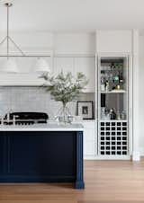 Kitchen and built-in bar, fully equipped with wine holders, benchspace for mixology and shelving backed by a darkened mirror.