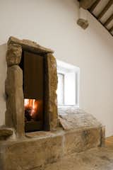A beautiful modern fireplace is set into an original stone hearth.