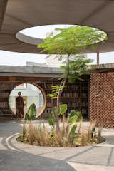 Located on the outskirts of Morelia, Mexico, the 5,920-square-foot UC House by architectural designer Daniela Bucio Sistos is grounded by a foyer with a raised, circular ceiling, which houses a tree that grows out from a hole in the floor at the center.&nbsp;From the atrium, a large glass wall reveals the library, which also features a circular cutout nestled between built-in bookshelves.