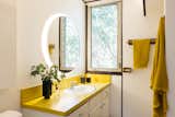 Echoing the kitchen, cheerful yellow Formica can also be found in both of home’s two bathrooms.