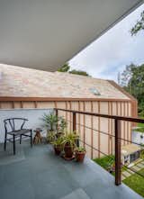 The sloped roof is clad using locally sourced pink slate which changes its hue by the movement of the sun. A gentle splash of rain brings out a shimmering effect on its surface. 