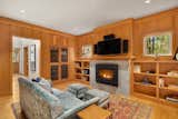 Primary Suite Sitting room / Library / Study with Bamboo Flooring, fireplace with limestone surround and Fir wood wall paneling/built-ins.