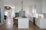 Kitchen, Ceramic Tile Backsplashe, Engineered Quartz Counter, Wall Oven, Pendant Lighting, Cooktops, Drop In Sink, Refrigerator, Microwave, Dishwasher, White Cabinet, and Light Hardwood Floor Kitchen  Photo 10 of 17 in Lakeview Residence by Wang Architects