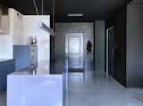 A concrete floor covered with a transparent resin is present throughout the apartment, so when you cross the front door, you have an irresistible impression that the floor is flowing, and the light reflecting in it intensifies this illusion. Some walls are in shades of black. Black ceilings deepened the effect of unlimited space. There are no traditional doors in the interior, only the bathroom and utility room were cut off and closed behind glass panes.