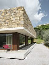 Exterior, Glass Siding Material, Concrete Siding Material, House Building Type, Flat RoofLine, Stone Siding Material, and Wood Siding Material Detail of the North facade  Photo 6 of 26 in HV Pavillon. A patio house at the foot of mount Amiata, Tuscany, Italy. by Nicola Gibertini