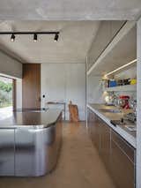 Kitchen, Concrete Counter, Ceiling Lighting, Metal Cabinet, Drop In Sink, Concrete Floor, Metal Counter, Track Lighting, Concrete Backsplashe, and Metal Backsplashe Kitchen  Photo 13 of 26 in HV Pavillon. A patio house at the foot of mount Amiata, Tuscany, Italy. by Nicola Gibertini