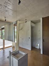Bath Room, One Piece Toilet, Concrete Counter, Concrete Floor, Ceiling Lighting, Freestanding Tub, Wood Counter, Open Shower, Pedestal Sink, Concrete Wall, and Floor Lighting Restroom  Photo 18 of 26 in HV Pavillon. A patio house at the foot of mount Amiata, Tuscany, Italy. by Nicola Gibertini