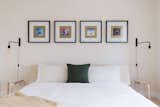 Warm lighting, cozy bedding, and modern art make the bedroom feel like home