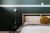 The cozy tertiary bedroom features a queen bed and forest green walls