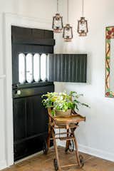 The kitchen's door to the side porch features original Victorian details; the sunny corner is perfect for the handmade stained glass mirror and Victorian convertible highchair/stroller 