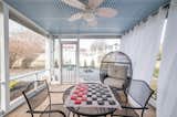 The sunporch leading to the firepit area features a traditional handmade Southern blue slat ceiling, and historic patterned brick floor