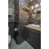 Hall bathroom updated with Schoolhouse + Hygge and West wallpaper, floor tile from Clay Imports, light fixture and pulls from CB2, and custom wainscotting. 