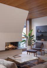 Living Room, Standard Layout Fireplace, Coffee Tables, Sofa, Rug Floor, Chair, Shelves, and Terrazzo Floor  Photo 11 of 19 in To Make Their Home Stand Out, They Covered It in Rows of Protruding Bricks